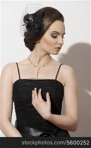 fashion shoot of lovely brunette lady posing with dark evening dress and elegant accessories, cute make-up and hair-style