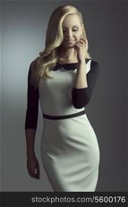 fashion shoot of lovely smiling blonde woman with elegant dress, long hair and shiny jewels