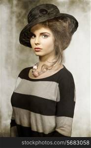 fashion shoot of pretty brunette with lovely black hat, striped dress and pink necklace.