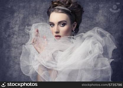 fashion shoot of pretty woman with romantic retro dame style. Wearing baroque dress with frill veil collar, precious earrings and tiara in the hair-style, elegant make-up