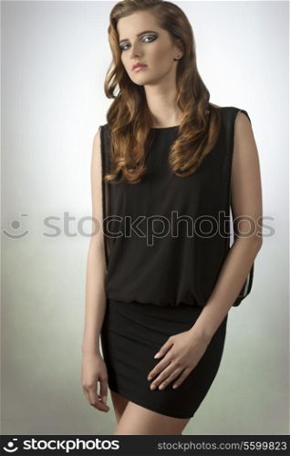 fashion shoot of sensual girl with long hair and elegant sexy black dress, cute make-up