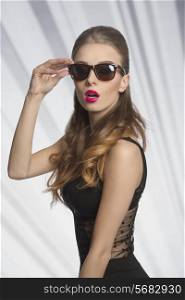 fashion shoot of very sexy woman with long wavy hair, stylish sunglasses and lace black dress