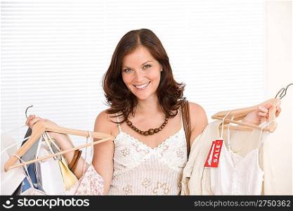 Fashion shopping - Happy woman choose sale clothes, holding shopping bag
