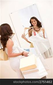 Fashion shopping - Happy woman choose sale clothes, holding shopping bag in mirror
