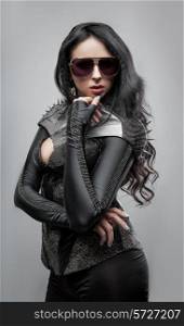 Fashion shot of a woman in sunglasses in corset with spikes