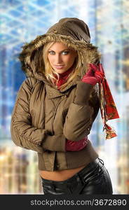 fashion shot of a young blond woman in winter jacket with hood and fur with shopping christmas bag