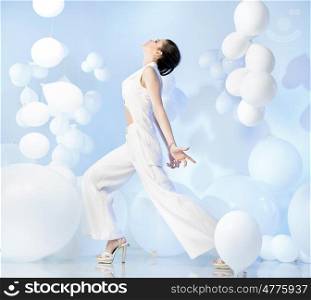 Fashion shot of adorable lady in studio full of balloons