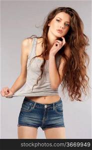 fashion shot of beautiful young woman with long curly hair in casual dress