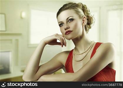 fashion shot of blond alluring woman elegant dress and pearl necklace