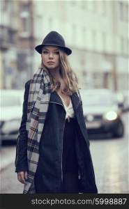 fashion shot of very cute model , in urban style , on the road , she is wearing scarf and hat, she has freckles on face