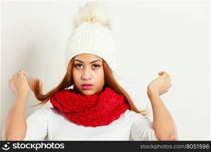 Fashion, snowy time people concept. Woman with red winter clothing. Mulatto model wearing warm cap and scarf