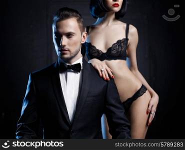 Fashion studio photo of a sensual couple in lingerie and a tuxedo