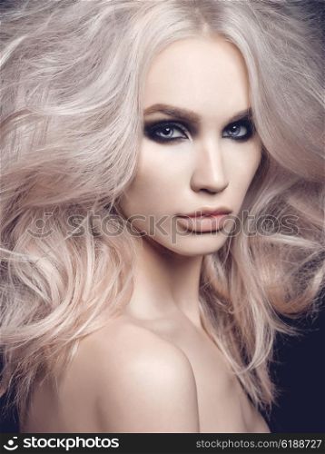 Fashion studio photo of beautiful blonde woman with smoky eyes makeup