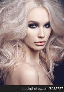 Fashion studio photo of beautiful blonde woman with smoky eyes makeup