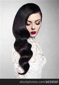 Fashion studio photo of beautiful model girl brunette with long curled hair and red lips. Hairstyle Hollywood wave. Wedding image hairstyle. Perfect makeup