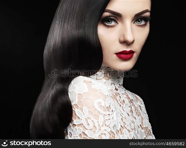 Fashion studio photo of beautiful model girl brunette with long curled hair and red lips. Hairstyle Hollywood wave. Wedding image hairstyle. Perfect makeup