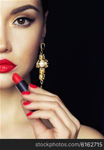 Fashion studio photo of beautiful young lady apply red lipstick. Perfect face makeup. Beauty and jewelry