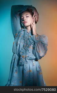 Fashion studio photo of young beautiful lady in blue chiffon dress on multi-colored background. Fashion and style. Fashion look book