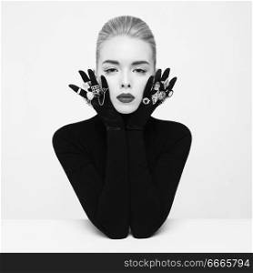 Fashion studio portrait of beautiful blonde lady with lot of precious rings. Conceptual photo. Jewelry