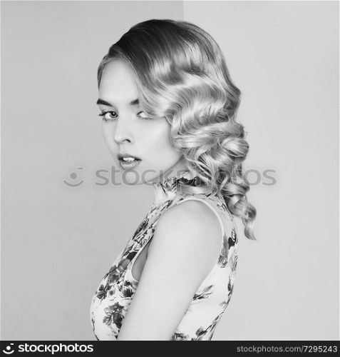 Fashion studio portrait of beautiful blonde woman with classic makeup. Beautiful woman in vintage dress pose in photo-studio. Elegant sexy lady with pretty face and professional hair-dress.
