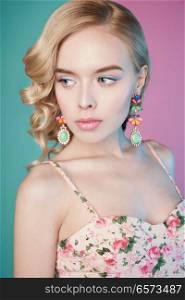 Fashion studio portrait of beautiful blonde woman with color makup on colorful background.  Perfect makeup in pastel shades. Hairstyle Hollywood wave                          