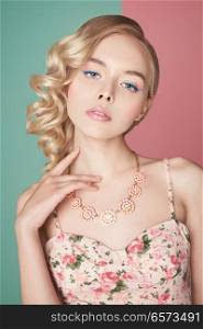 Fashion studio portrait of beautiful blonde woman with color makup on colorful background. Perfect makeup in pastel shades. Hairstyle Hollywood wave