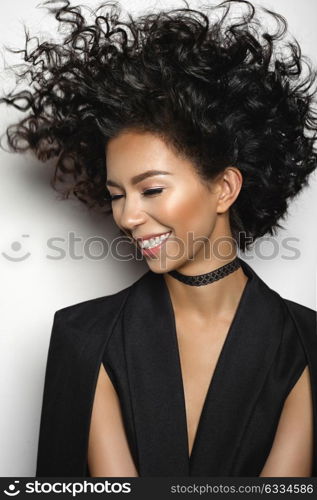 Fashion studio portrait of beautiful mulatto woman with afro curls hairstyle. Fashion and style. Beauty and health