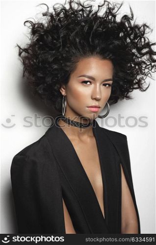 Fashion studio portrait of beautiful mulatto woman with afro curls hairstyle. Fashion and style. Beauty and health