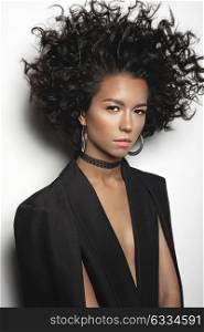 Fashion studio portrait of beautiful mulatto woman with afro curls hairstyle. Fashion and style. Beauty and health