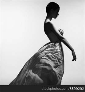 Fashion studio portrait of beautiful woman in long evening dress on gray background. Asian beauty.
