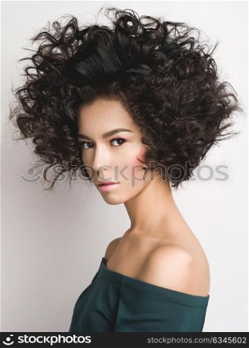 Fashion studio portrait of beautiful woman with afro curls hairstyle. Fashion and beauty