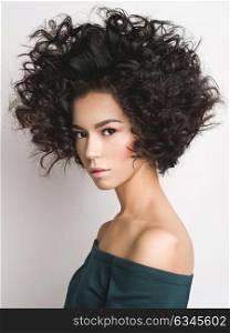 Fashion studio portrait of beautiful woman with afro curls hairstyle. Fashion and beauty