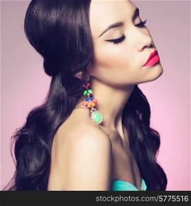 Fashion studio portrait of beautiful young woman with earring. Jewelry and accessories