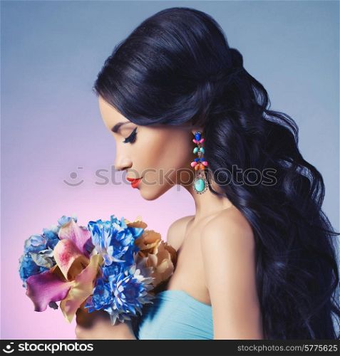 Fashion studio portrait of beautiful young woman with flowers. Jewelry and accessories