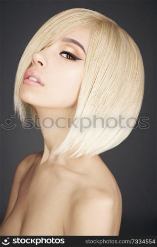 Fashion studio portrait of lovely asian woman with blonde short hair. Fashion and beauty. Bright makeup. Fashionable haircut. Sexy young model with beautiful eyes