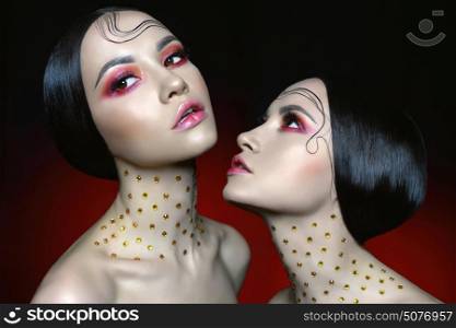 Fashion studio portrait of two beautiful women with bright red makeup. Fashion and Beauty. Perfect makeup