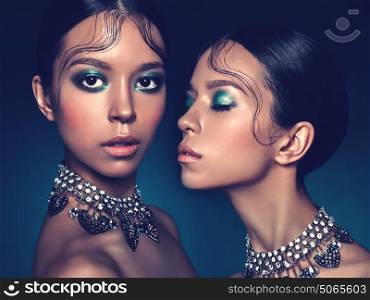 Fashion studio portrait of two twins beautiful asian women with diamond necklace. Fashion and Beauty. Perfect makeup