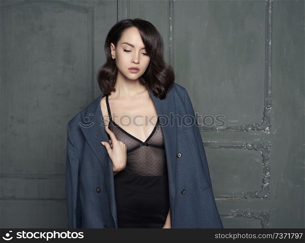 Fashion studio portrait of young beautiful woman in a man&rsquo;s jacket. Fashion and style