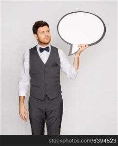 fashion, style and communication concept - concerned man in suit holding blank text bubble banner. man in suit holding blank text bubble banner