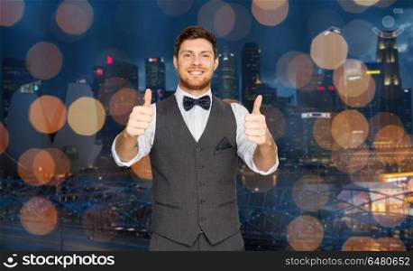 fashion, style and gesture concept - happy man in festive suit showing thumbs up over singapore city night lights background. happy man showing thumbs up over singapore city. happy man showing thumbs up over singapore city