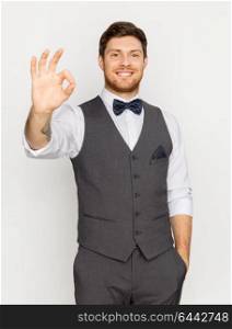 fashion, style and gesture concept - happy man in festive suit showing ok hand sign. happy man in festive suit showing ok hand sign