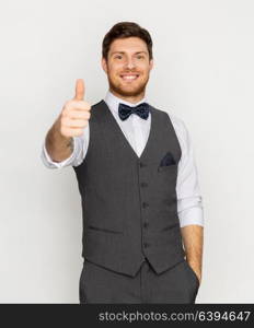 fashion, style and gesture concept - happy man in festive suit showing thumbs up. happy man in festive suit showing thumbs up
