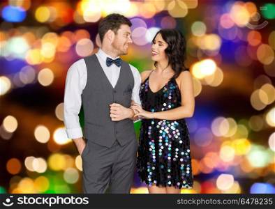 fashion, style and holidays concept - happy couple at party over festive lights background. happy couple hugging at party over festive lights . happy couple hugging at party over festive lights