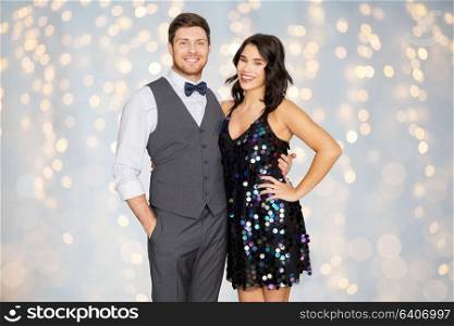 fashion, style and holidays concept - happy couple hugging at party over festive lights background. happy couple hugging at party