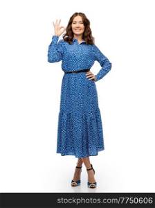 fashion, style and people concept - happy smiling beautiful young woman posing in blue dress showing ok gesture over white background. happy young woman in blue dress showing ok gesture
