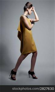 Fashion style - elegant brunette girl in trendy dress posing in studio. Series of photos