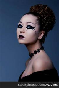 Fashion style portrait of a woman with dramatic theatrical make up on her face