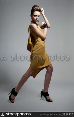 Fashion style - young beautiful caucasian woman brunette posing on grey background