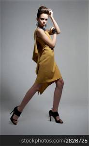 Fashion style - young beautiful caucasian woman brunette posing on grey background