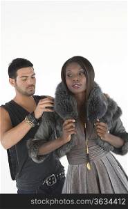 Fashion stylist helps model with fake fur jacket